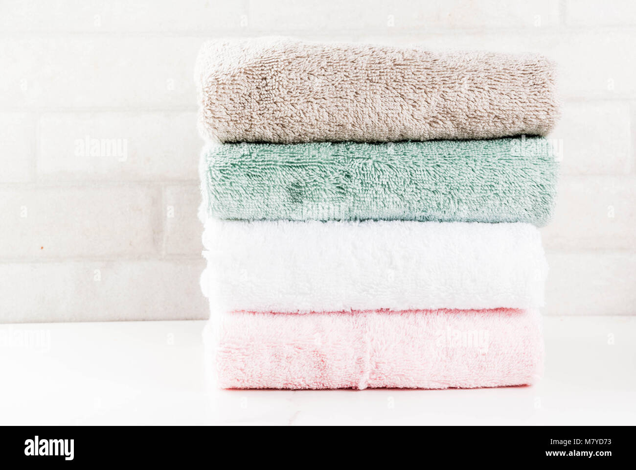 Vous pourrez vous détendre et d'une baignoire spa concept, nettoyer la pile de serviettes de bain en coton bouclé de couleur dans la salle de bain textile fond blanc, copie espace Vue de dessus Banque D'Images