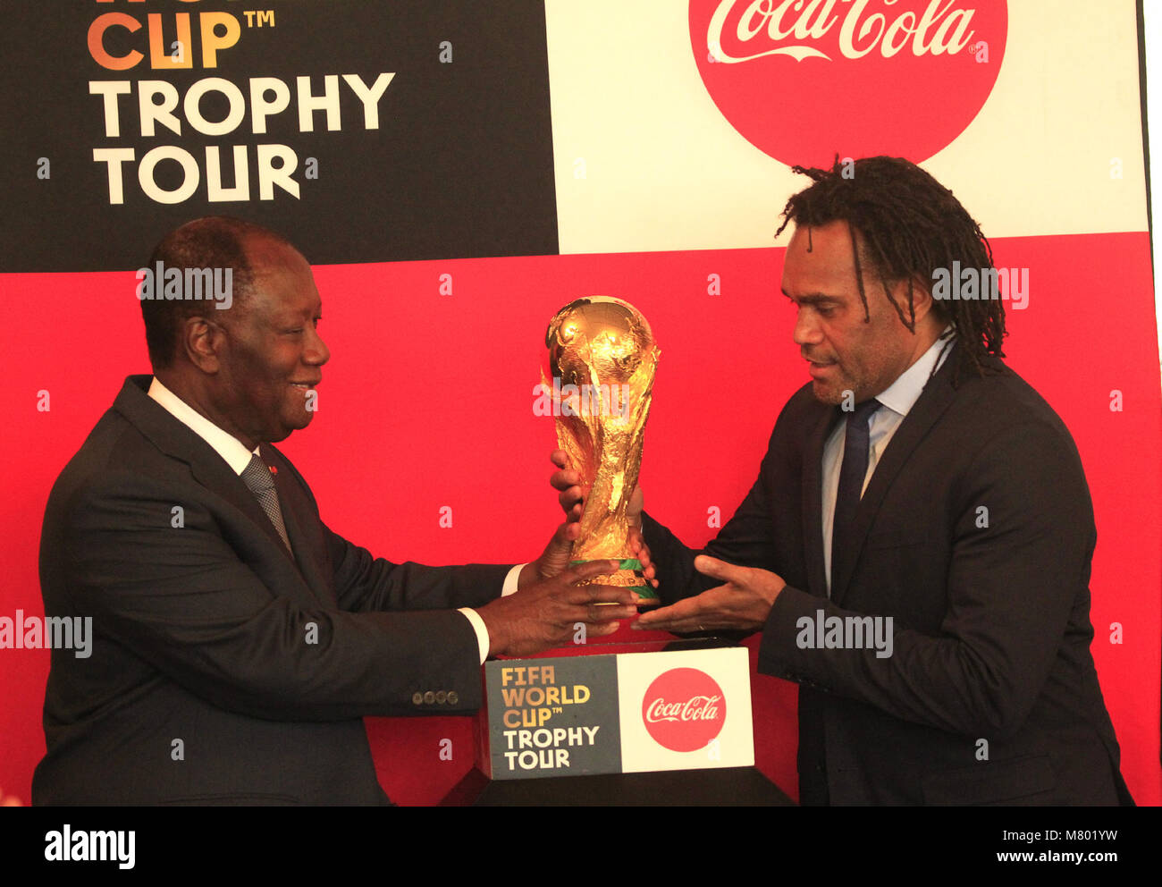 (180314) -- ABIDJAN, 14 mars 2018 (Xinhua) -- la Côte d'Ivoire, le président Alassane Ouattara (G) et ancien joueur de football français Christian Karembeu tenir la FIFA Coupe du monde pendant la Coupe du Monde FIFA world tour trophée à Abidjan, Côte d'Ivoire, le 13 mars 2018. (Xinhua/Yvan Sonh) Banque D'Images