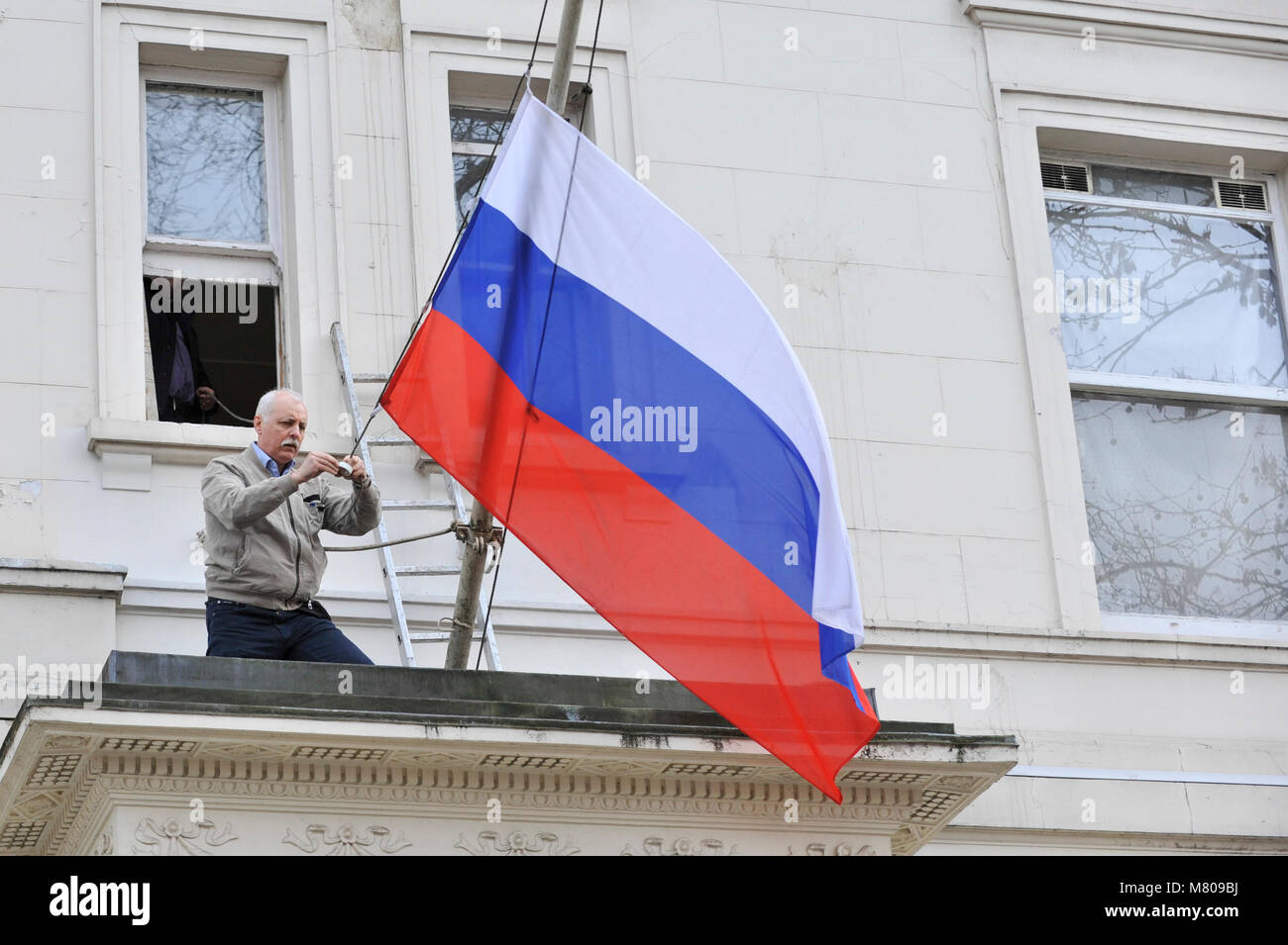 Londres, Royaume-Uni. 14 mars 2018. Un ouvrier remplace un drapeau endommagé à l'extérieur de l'affiche Ambassade de Russie dans Kensington. La Grande-Bretagne a donné 23 diplomates russes une semaine pour quitter le pays après l'attaque de Sergueï Skripal ex-espion et sa fille Julia avec le gaz neurotoxique à Salisbury. Crédit : Stephen Chung / Alamy Live News Banque D'Images