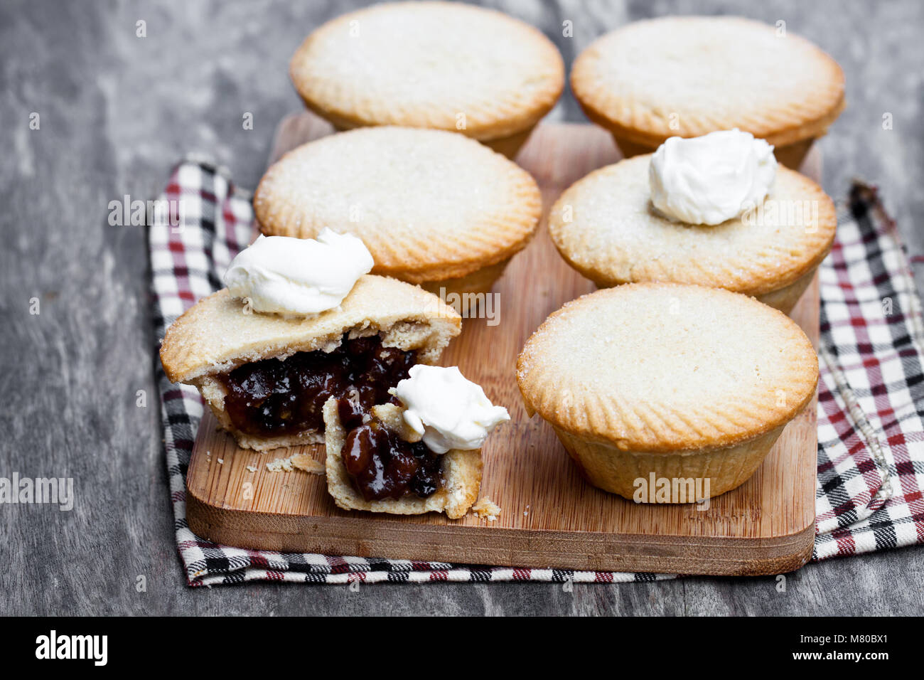 Mince pie group sur une planche à découper sur fond de bois Banque D'Images