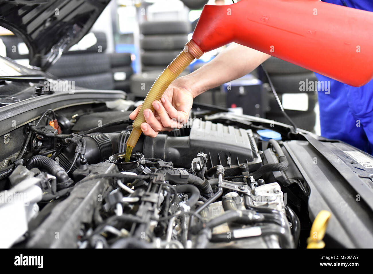 Le changement d'huile du moteur d'une voiture à un atelier par un mécanicien professionnel - le service après-vente Banque D'Images