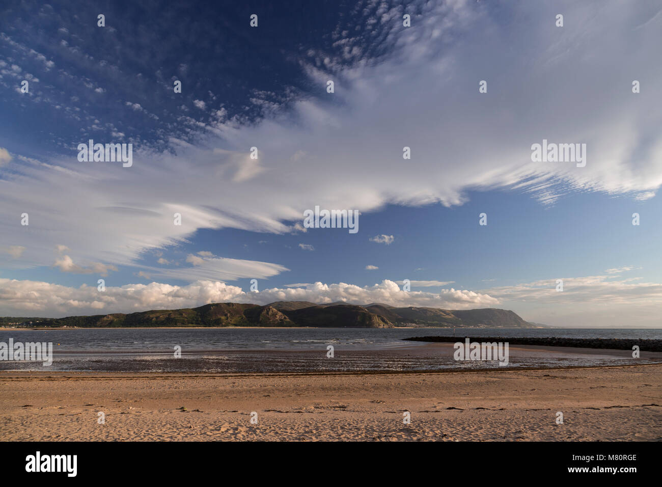 Nuages au-dessus des vagues au coucher du soleil de la rive ouest de Llandudno, côte Nord du Pays de Galles Banque D'Images