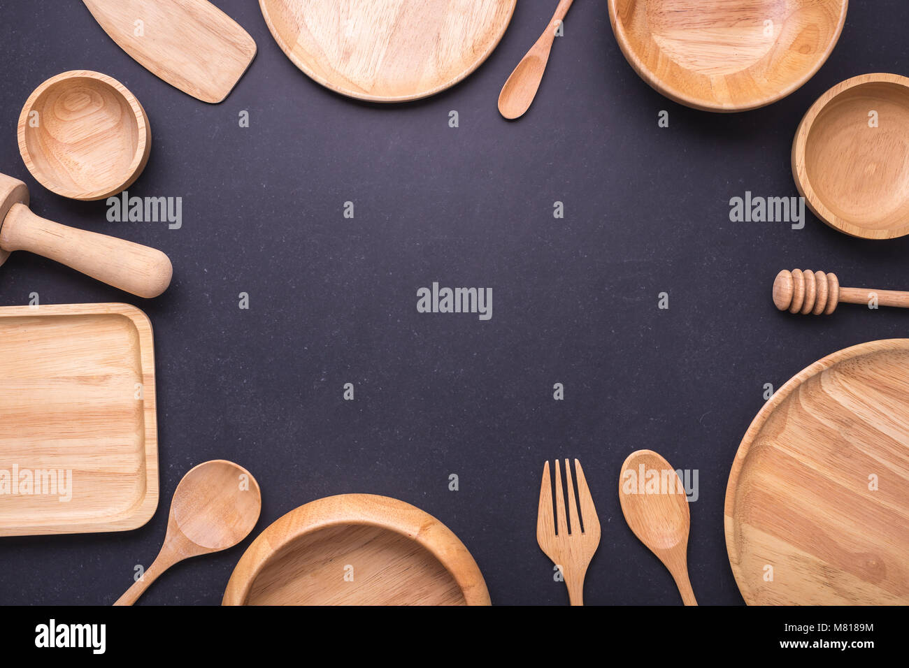 Nouvelle collection de ustensile de cuisine en bois, bol, assiette, cuillère, assiette. Studio shot sur arrière-plan du tableau noir. Avec de l'espace libre pour le texte ou dessin Banque D'Images