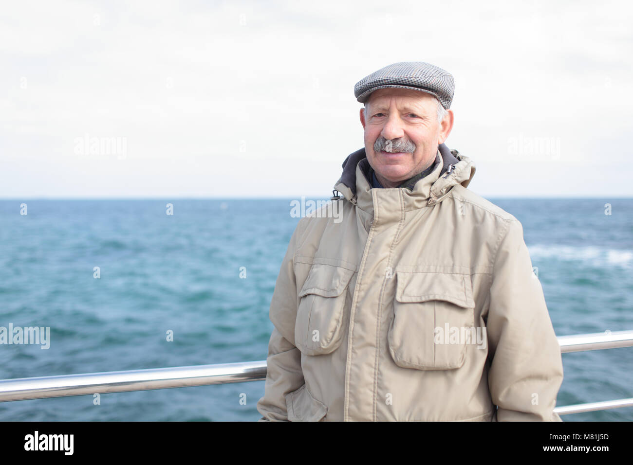 Man sur la jetée contre la mer dans une journée de printemps Banque D'Images