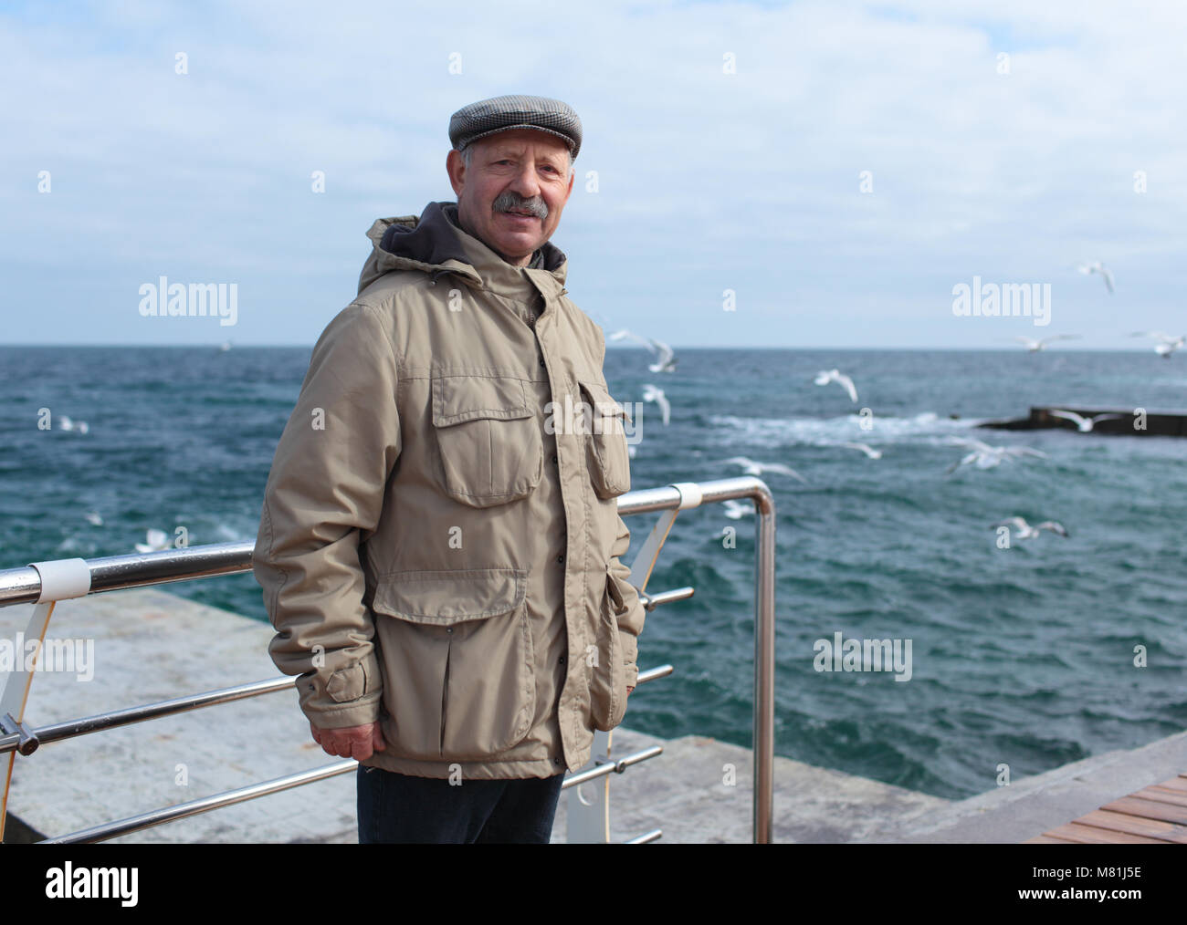 Man sur la jetée contre la mer dans une journée de printemps Banque D'Images