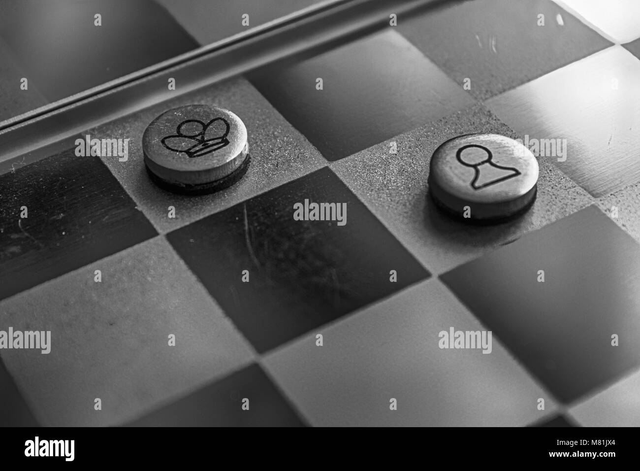 Photo monochrome avec une photo d'un conseil d'acier d'échecs et des pièces de métal, pièces d'échecs sur un échiquier avec réflexion. Banque D'Images