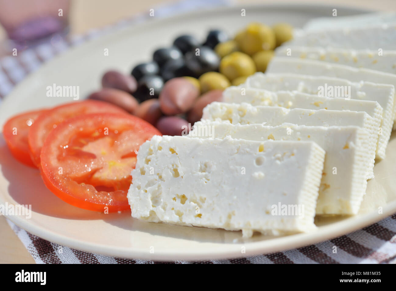 Fromage, olives, et les tranches de tomate sur une plaque Banque D'Images