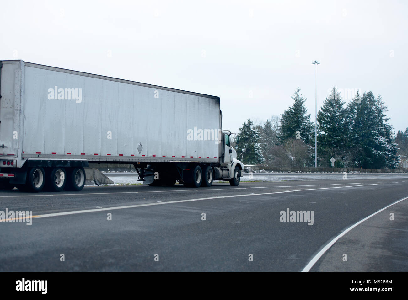 Gros Camion Camion semi cabine de jour pour des livraisons locales du fret commercial en semi-remorque van sec fonctionnant en hiver par temps de tempête de neige sur l'interstate multi Banque D'Images