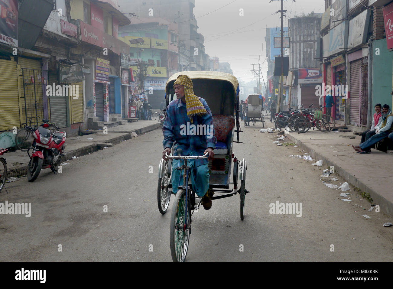 Homme conduisant un vélo à trois roues en Inde Banque D'Images