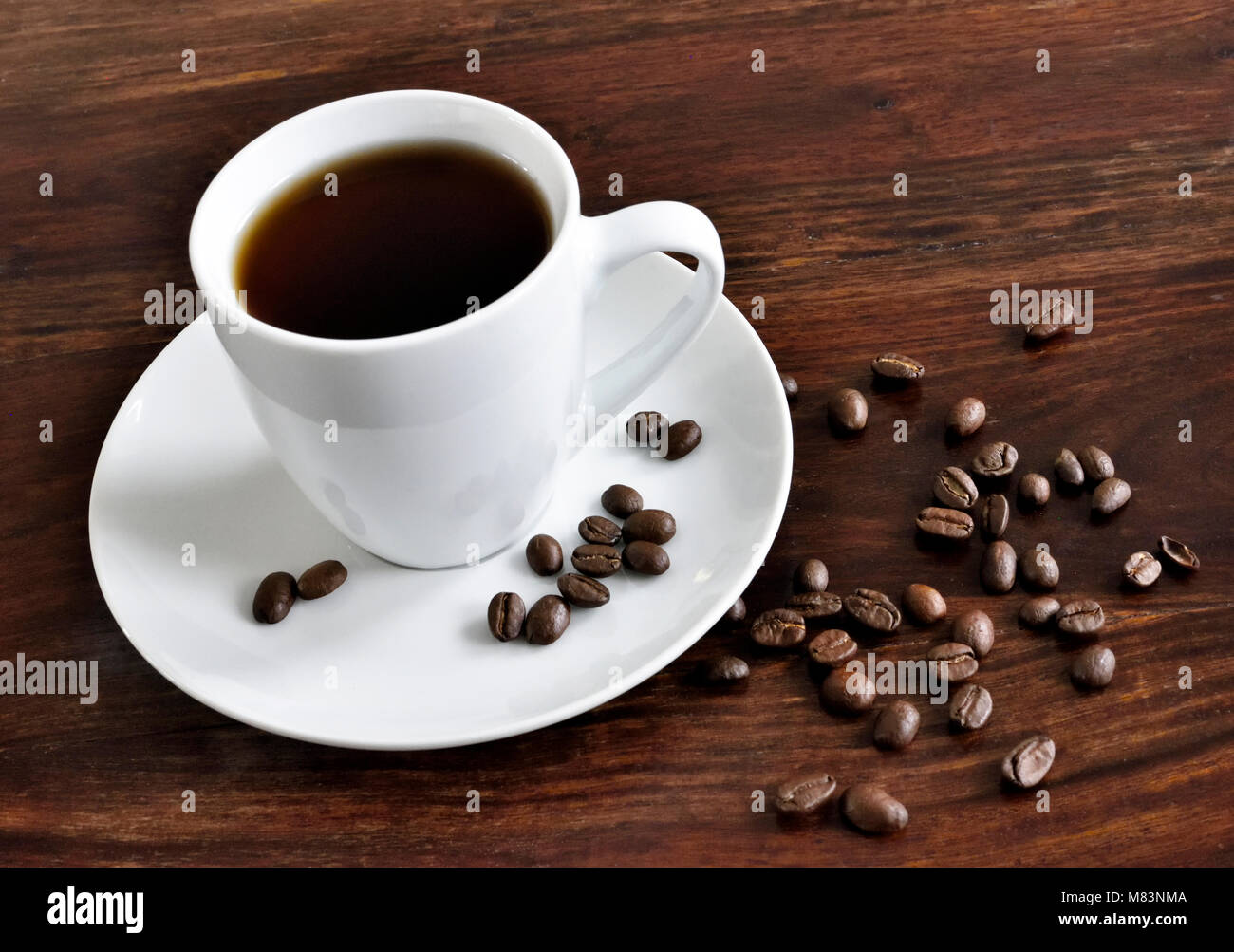 Scène de petit-déjeuner avec café tasse, livre ouvert et les grains de café sur une table en bois. Scène du matin avec du café chaud. Banque D'Images