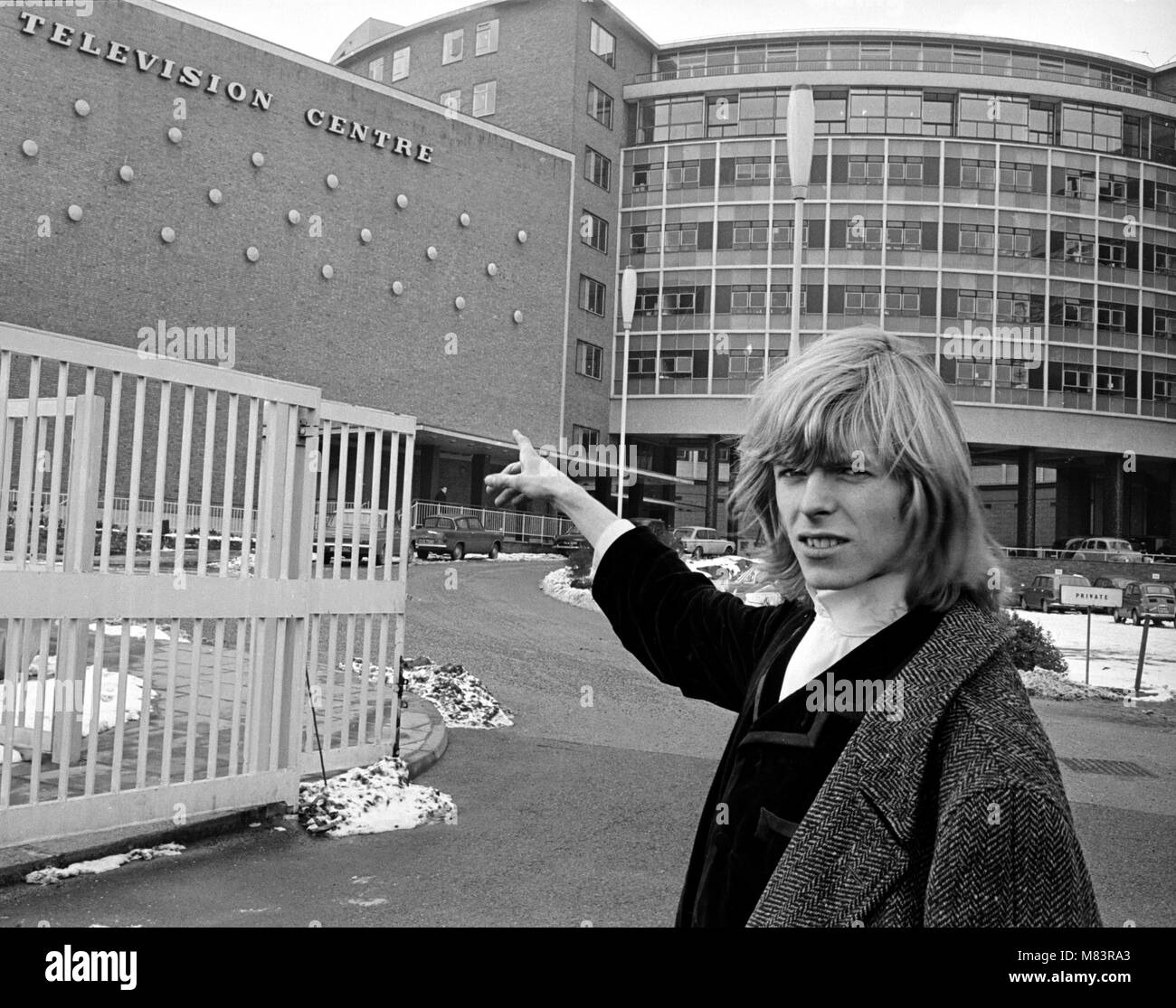 Le chanteur David Bowie quand il était connu sous le nom de Davy Jones, illustré à l'extérieur de la BBC Television Center où lui et sa bande sont à effectuer J'ai pitié de l'imbécile sur la BBC show 'Gadzooks ! Tout se passe'. Le producteur du show Barry Langford a insisté pour que Bowie couper ses cheveux qu'il a refusé de faire et organisé des manifestations à la BBC avec des bannières comme 'être juste de longs cheveux". Le groupe ont ensuite permis d'apparaître dans l'émission avec la condition que si ils se sont plaintes, les frais devraient aller à la charité. Aucune plainte n'a été reçu. Mars 1965 Banque D'Images