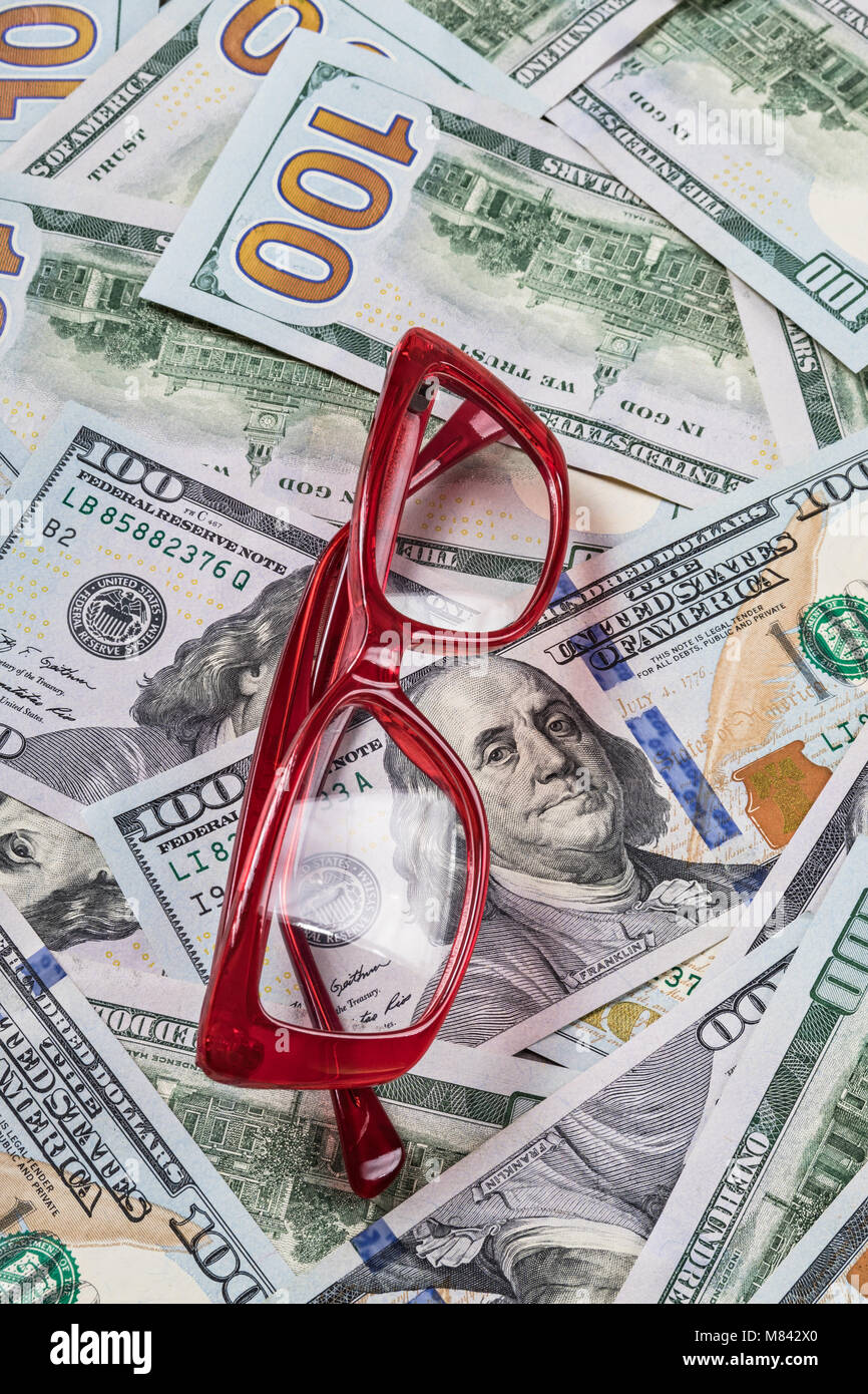 Lunettes rouges comptables sur fond argent dollar Banque D'Images