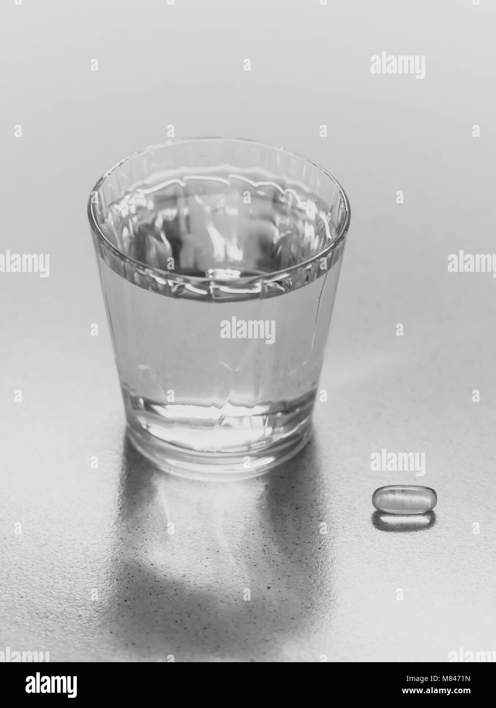 Capsule avec un verre d'eau sur la table Banque D'Images