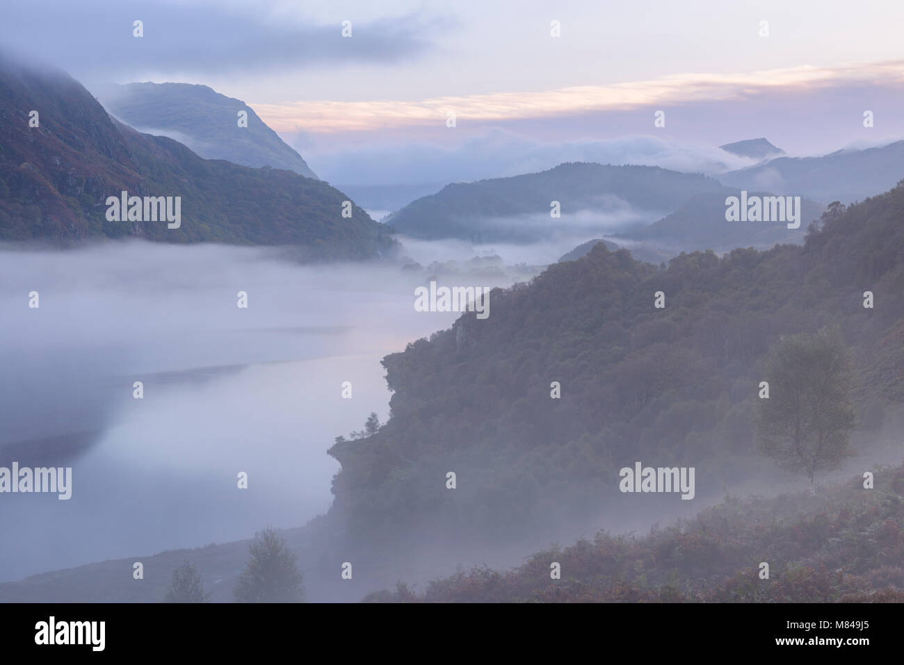 Mist suaires Llyn Dinas à l'aube dans le parc national de Snowdonia, Pays de Galles, Royaume-Uni. L'automne (septembre) 2017. Banque D'Images