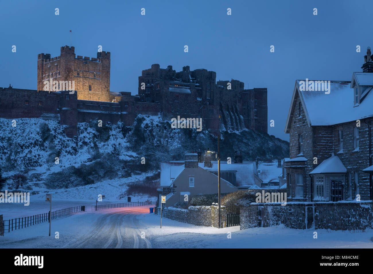 Village et Château de Bamburgh avec neige de l'hiver, Northumberland, Angleterre. L'hiver (février) 2018. Banque D'Images