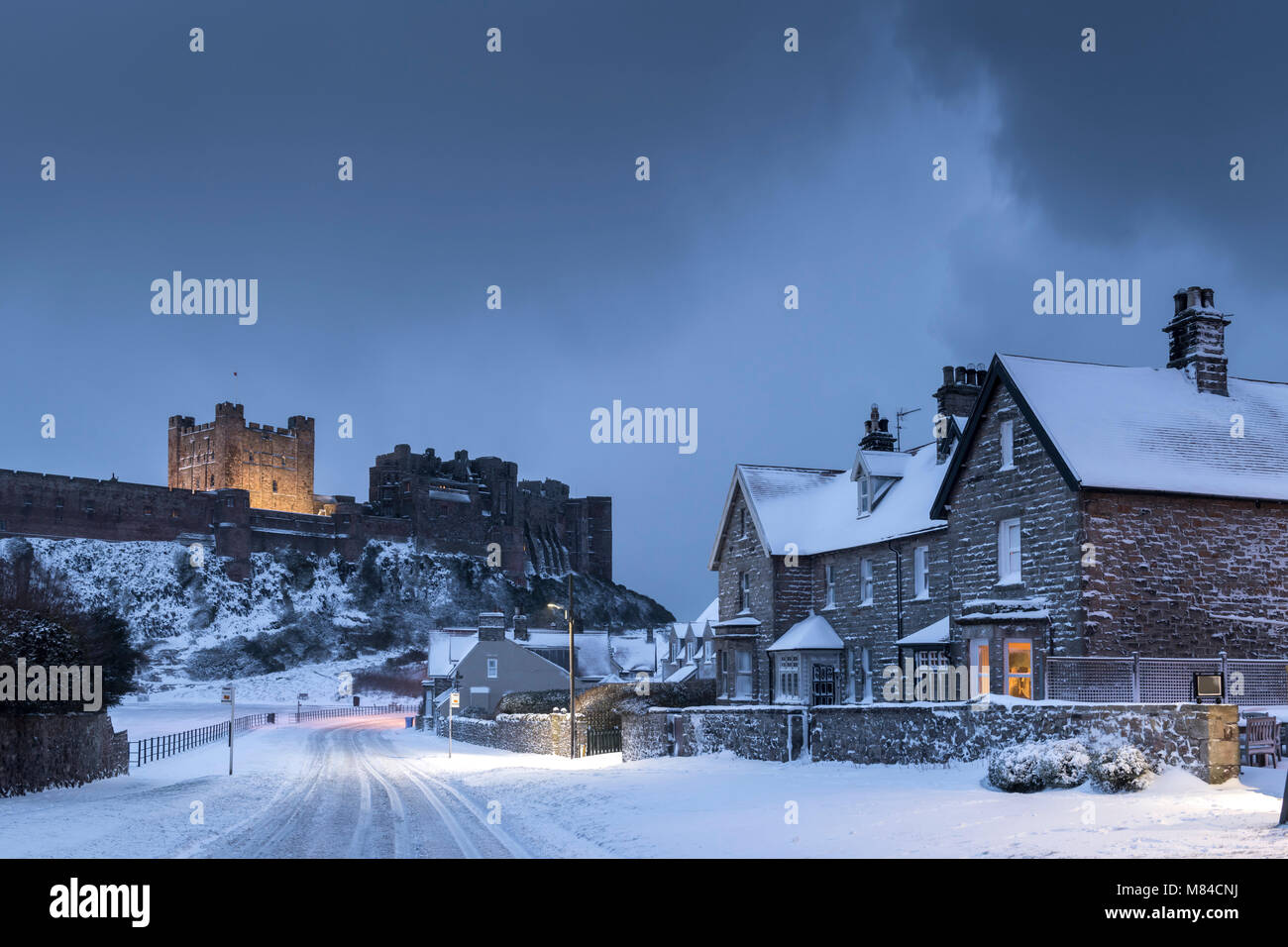 Château de Bamburgh et village de neige de l'hiver, Northumberland, Angleterre. L'hiver (février) 2018. Banque D'Images