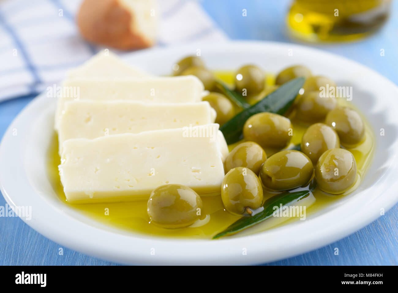 Tranches de fromage Feta et olives vertes sur une plaque Banque D'Images