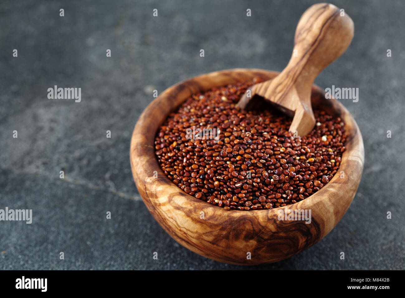 Graines de quinoa rouge au bol en bois. Arrière-plan de Chenopodium quinoa close up, copy space Banque D'Images