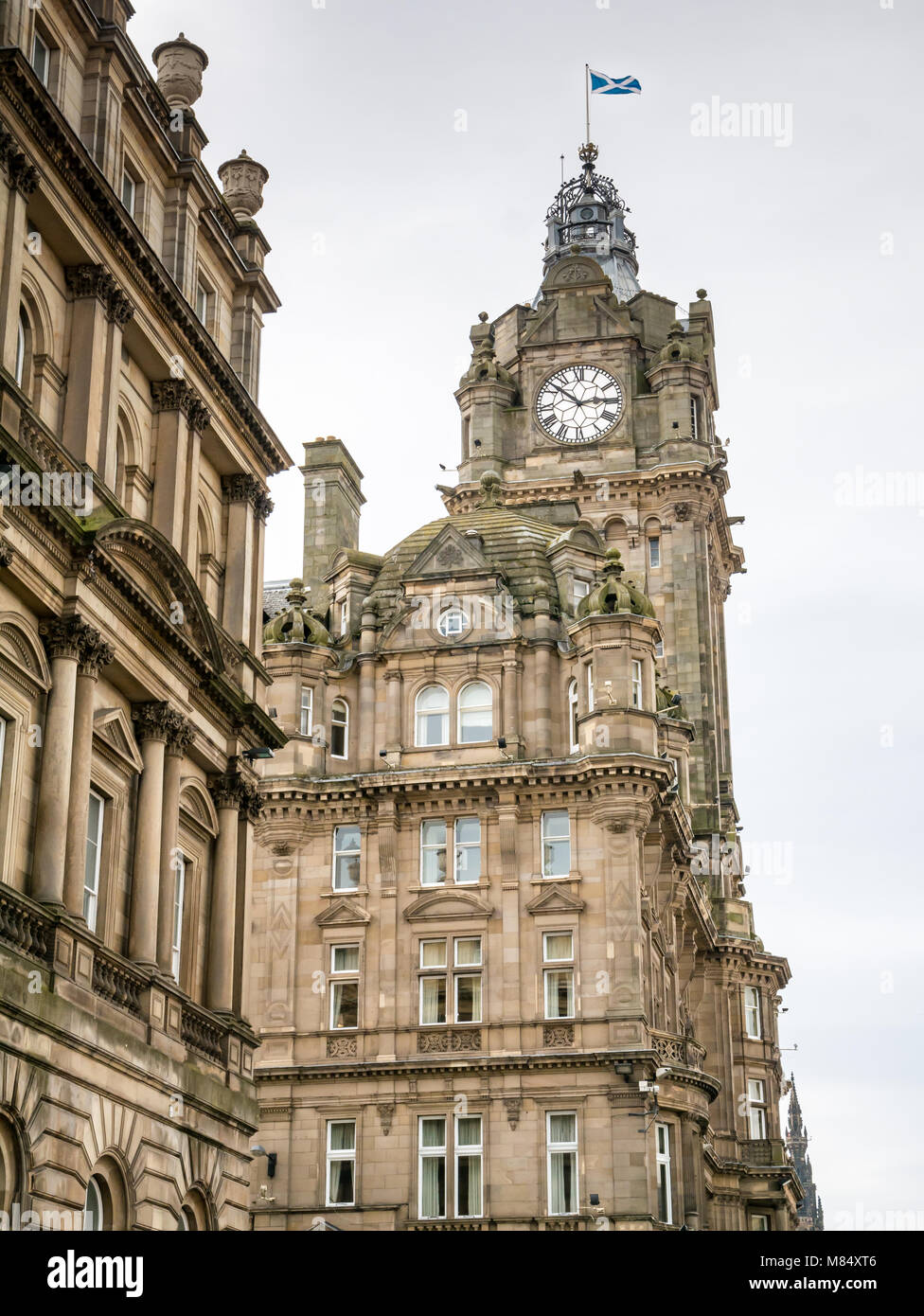À la recherche jusqu'à l'époque victorienne ornée Balmoral Hotel tour de l'horloge, Princes Street, Edinburgh, Ecosse, Royaume-Uni, avec sautoir flag flying Banque D'Images