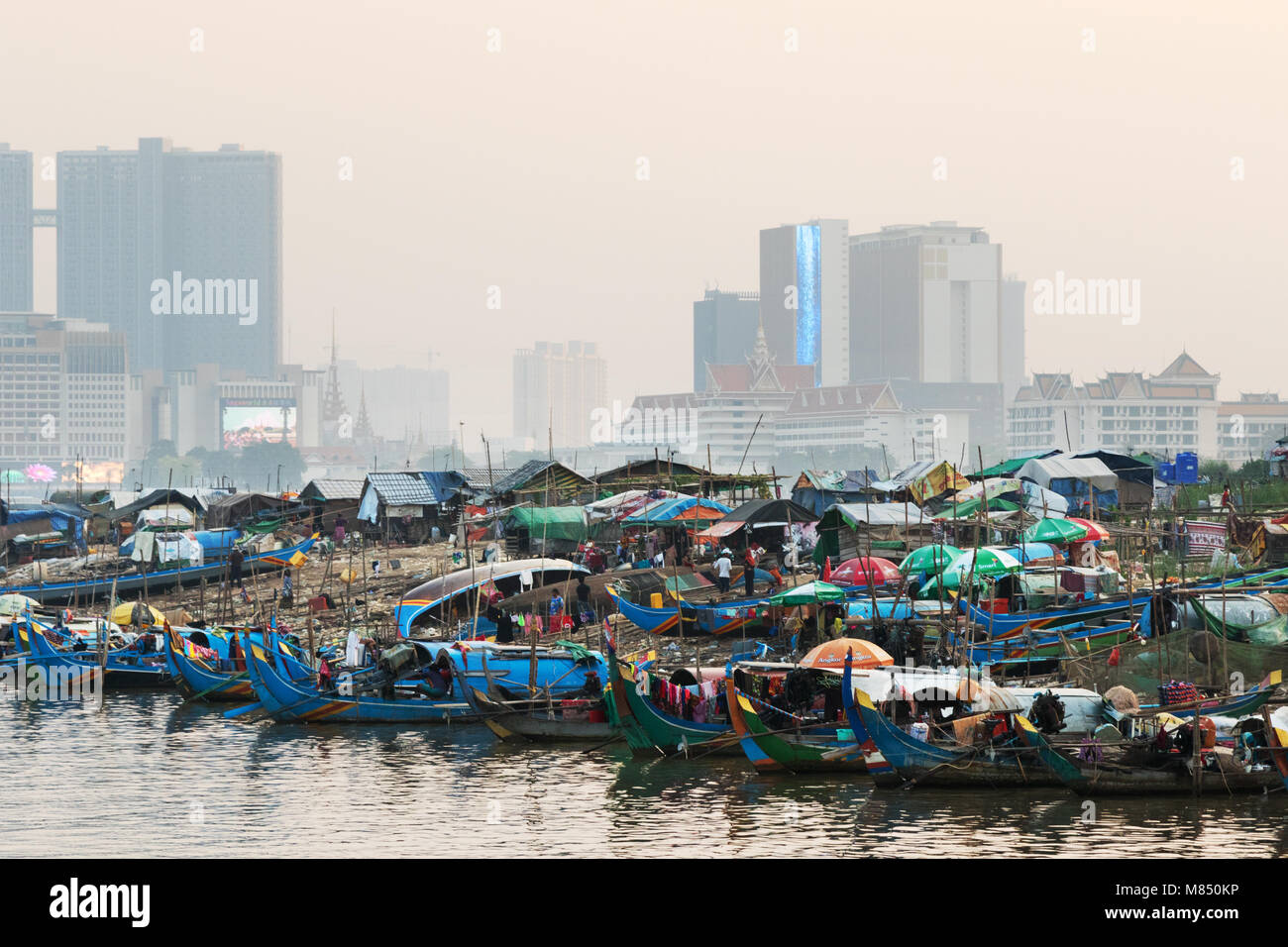 Cambodge - riches et pauvres contraste - un village flottant sur le Mékong en face des hôtels modernes, Mékong, Phnom Penh, Cambodge Asie Banque D'Images