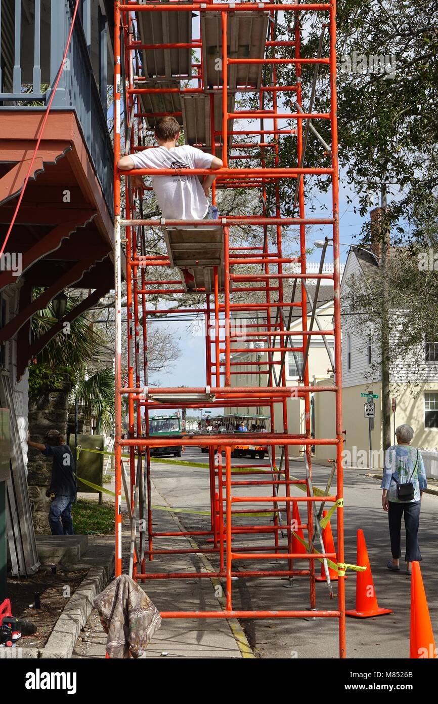 L'homme se détend sur un échafaudage à côté d'un immeuble en rénovation à Saint Augustine, Floride Banque D'Images