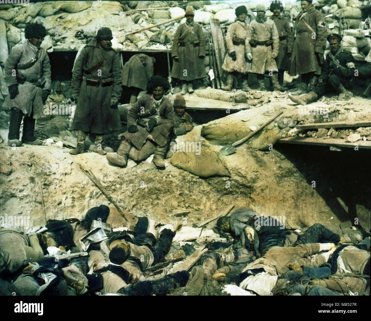 Photo colorisée des soldats russes debout dans une tranchée au-dessus des cadavres de soldats japonais morts pendant la guerre russo-japonaise, 1905. (Photo de Burton Holmes) Banque D'Images