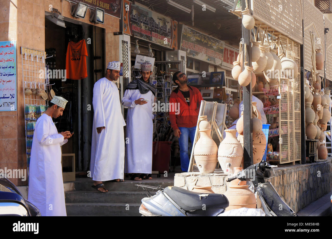Sur, Oman, Janvier 1,2014 : discuter de traders en face d'une rangée de magasins vendant des souvenirs pour les touristes, au Moyen-Orient Banque D'Images