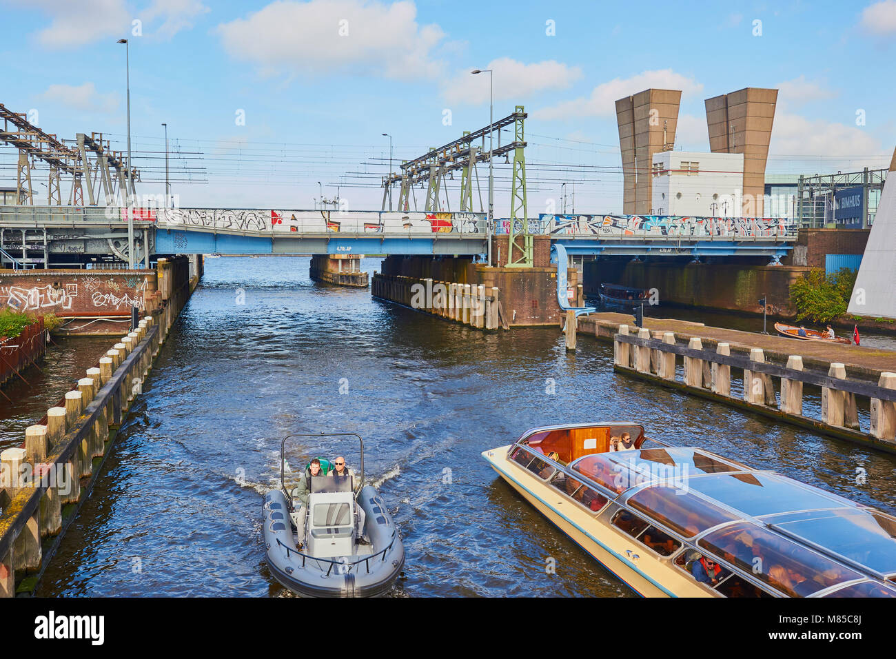 Des bateaux touristiques sur canal dans l'est des docks, à Amsterdam, Pays-Bas Banque D'Images