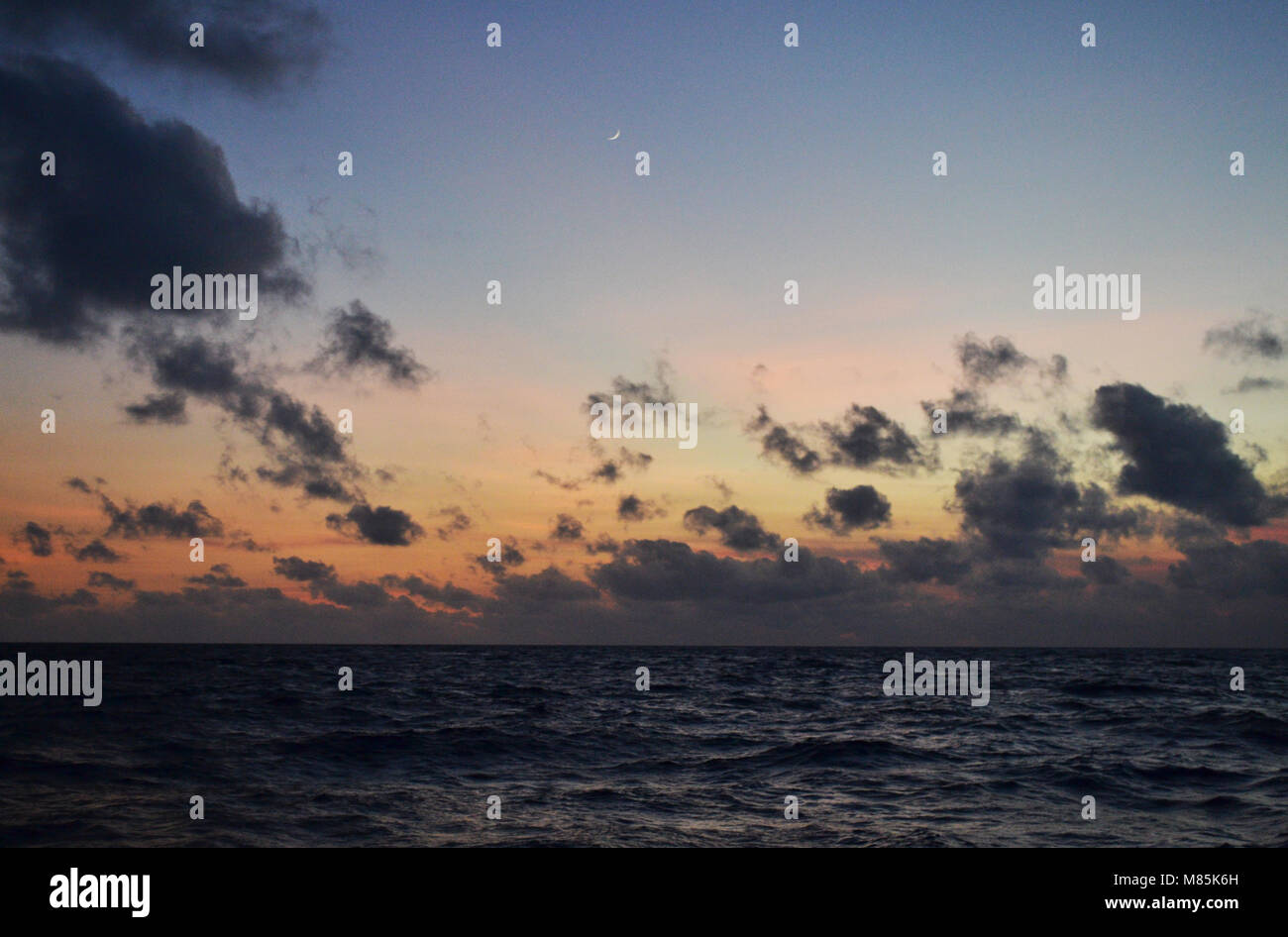 De soleil colorés фта nouvelle lune dans l'océan Banque D'Images