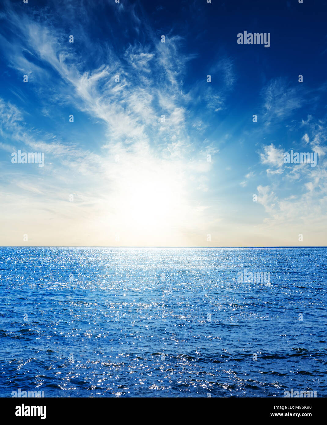 Le bleu foncé de la mer et du ciel avec nuages dans le coucher du soleil Banque D'Images
