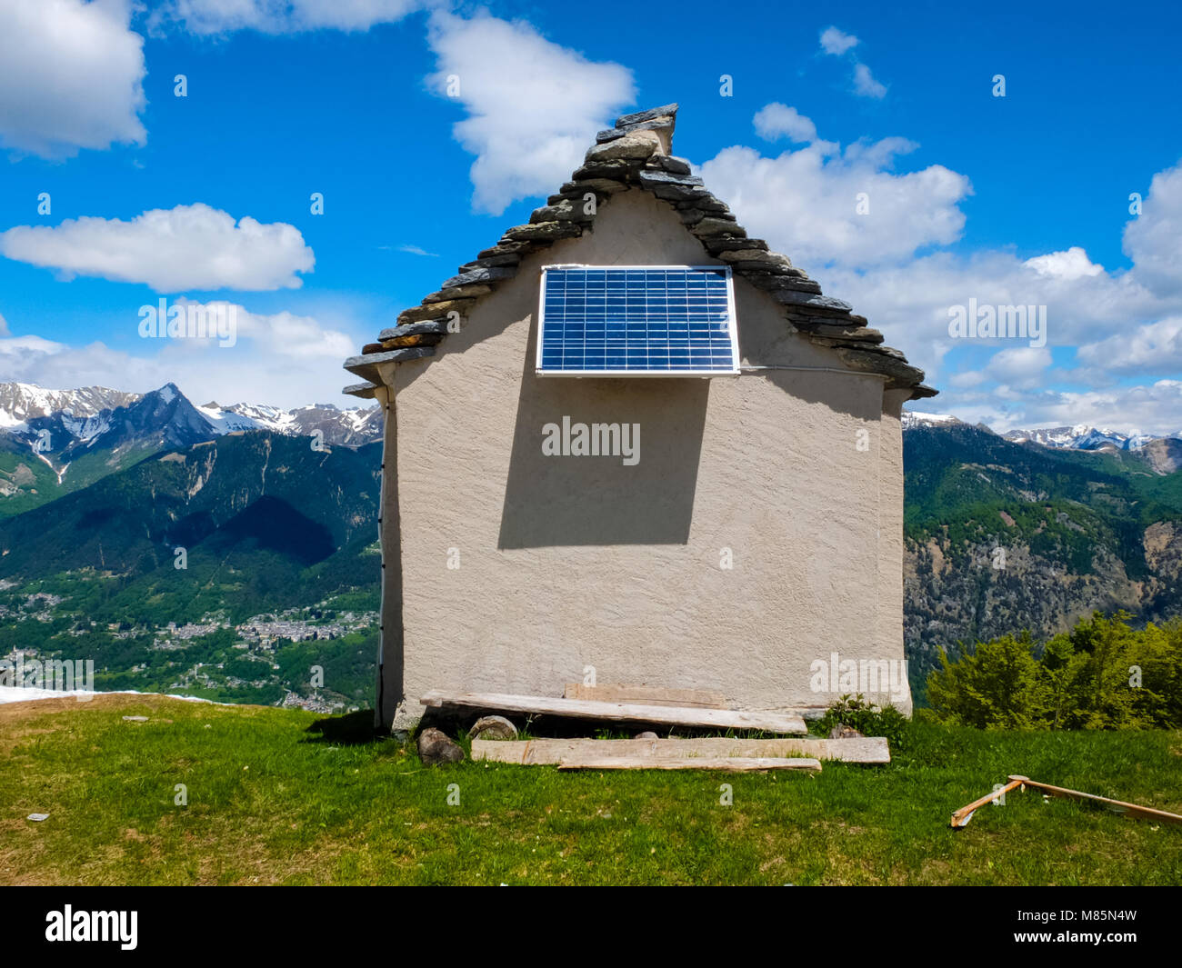 Petite maison sur une crête de montagne avec panneau solaire Ciel bleu avec quelques nuages blancs Banque D'Images