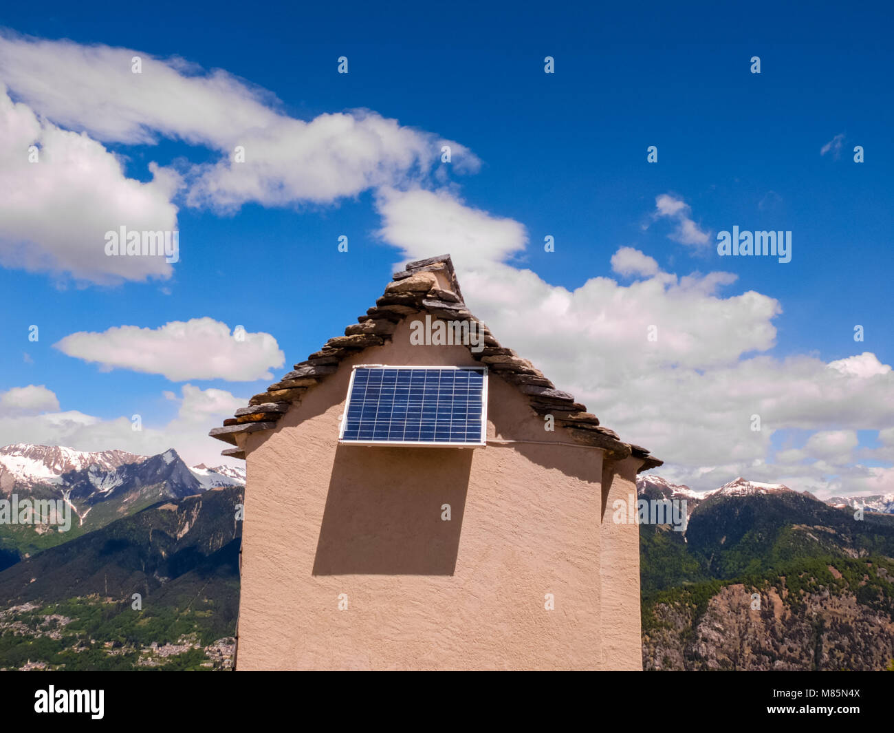 Petite maison sur une crête de montagne avec panneau solaire Ciel bleu avec quelques nuages blancs Banque D'Images