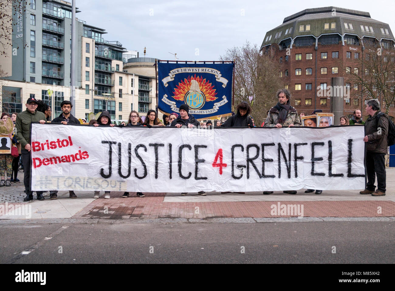 Bristol, Royaume-Uni, le 14 mars, 2018. La population locale portant des pancartes portant la photo de l'un de ceux qui sont morts dans la tragédie sont représentés comme ils prennent part à une marche silencieuse pour les victimes d'incendie de la tour de Grenfell. La marche organisée par Bristol4Grenfell et soutenu par la campagne Justice Pour Grenfell et Bristol Assemblée du peuple a eu lieu afin de permettre aux gens de manifester leur solidarité avec les habitants de London's estate Grenfell, dont la lutte pour la justice continue de plus de huit mois après l'incendie qui a tué 71 personnes. Credit : lynchpics/Alamy Live News Banque D'Images