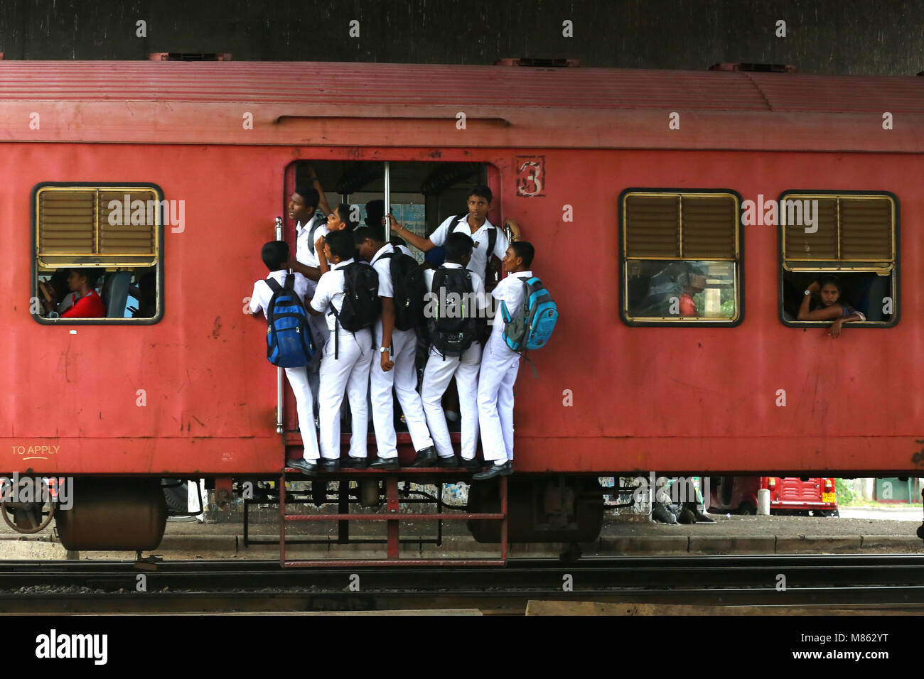 L'École Childern voyageant sur le marchepied du train après l'École de Colombo à Gampaha. Banque D'Images