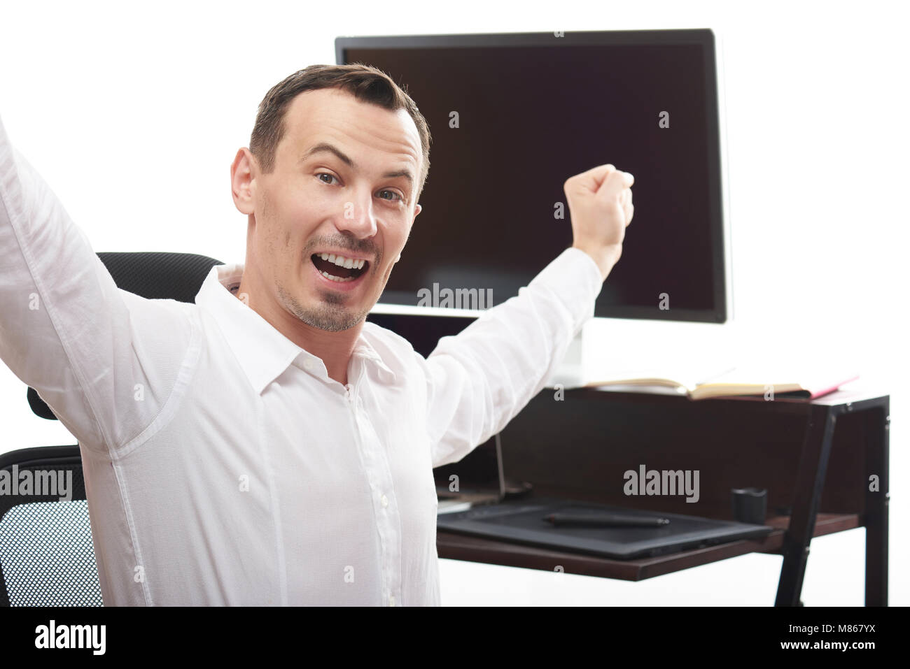 Jeune homme gagnant dans office avec les mains. Homme soulever ses mains Banque D'Images