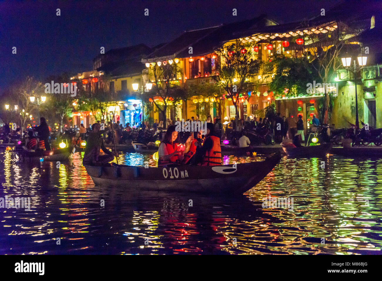 Les touristes faire une balade le long de la rivière de déposer une  lanterne à bougie flottante dans l'eau à Hoi An, Vietnam Photo Stock - Alamy