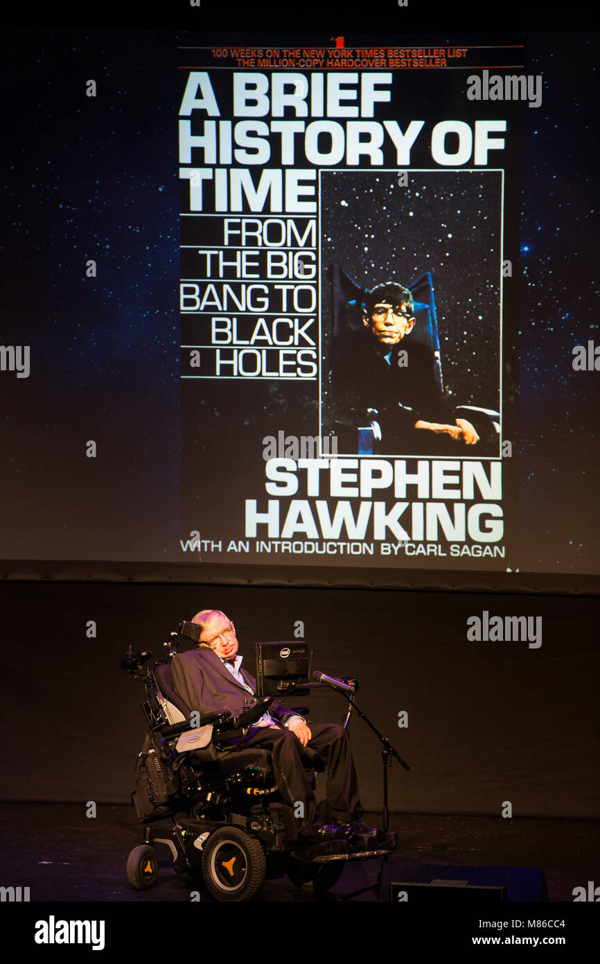 Le professeur Stephen Hawking, scientifique britannique, physicien de renommée mondiale et portrait Une brève histoire du temps, sa couverture de livre sur l'écran de projection, Banque D'Images