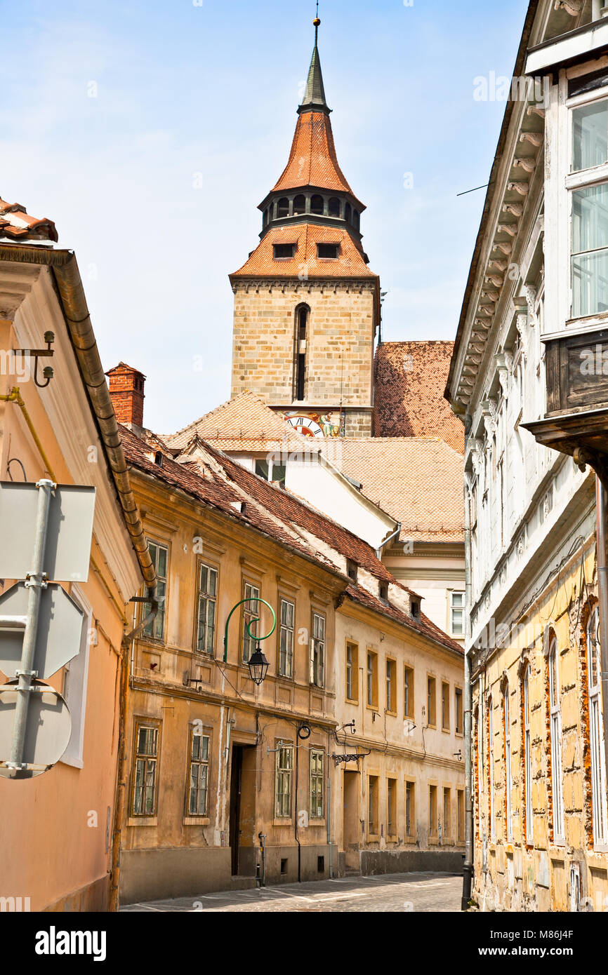 Rue du centre-ville étroite avec l'Église Noire ( Biserica neagra) de Brasov, en Transylvanie, Roumanie. Banque D'Images