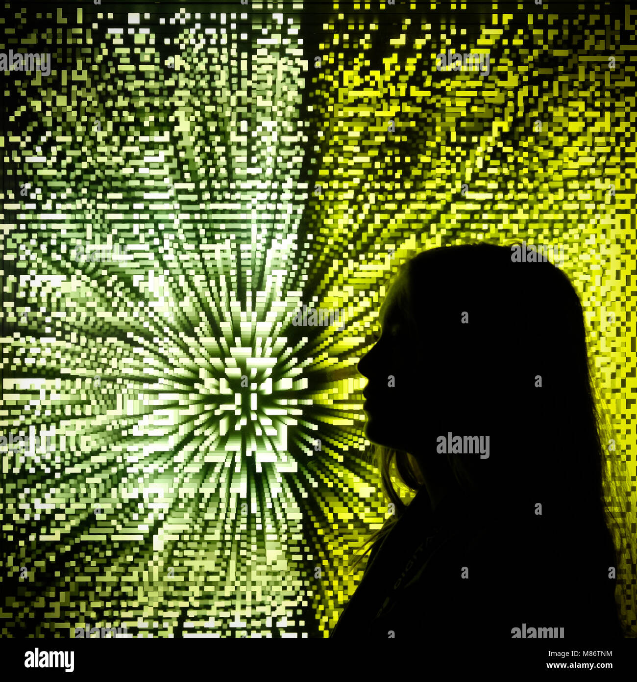 Silhouette d'une jeune fille debout devant un écran numérique Banque D'Images