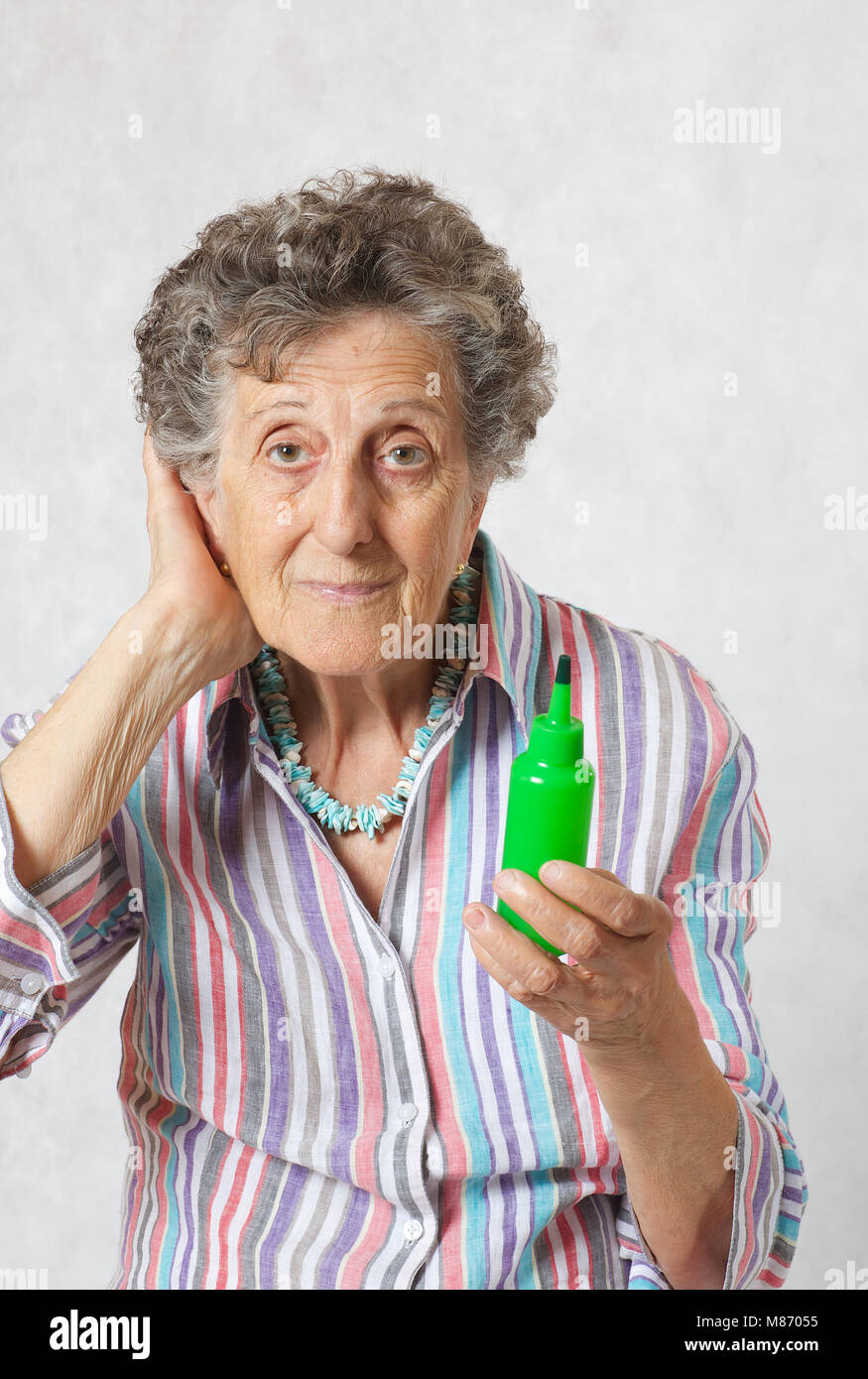 Vieille Femme entre 70 et 80 ans garde les poils de ses mains le sérum Banque D'Images