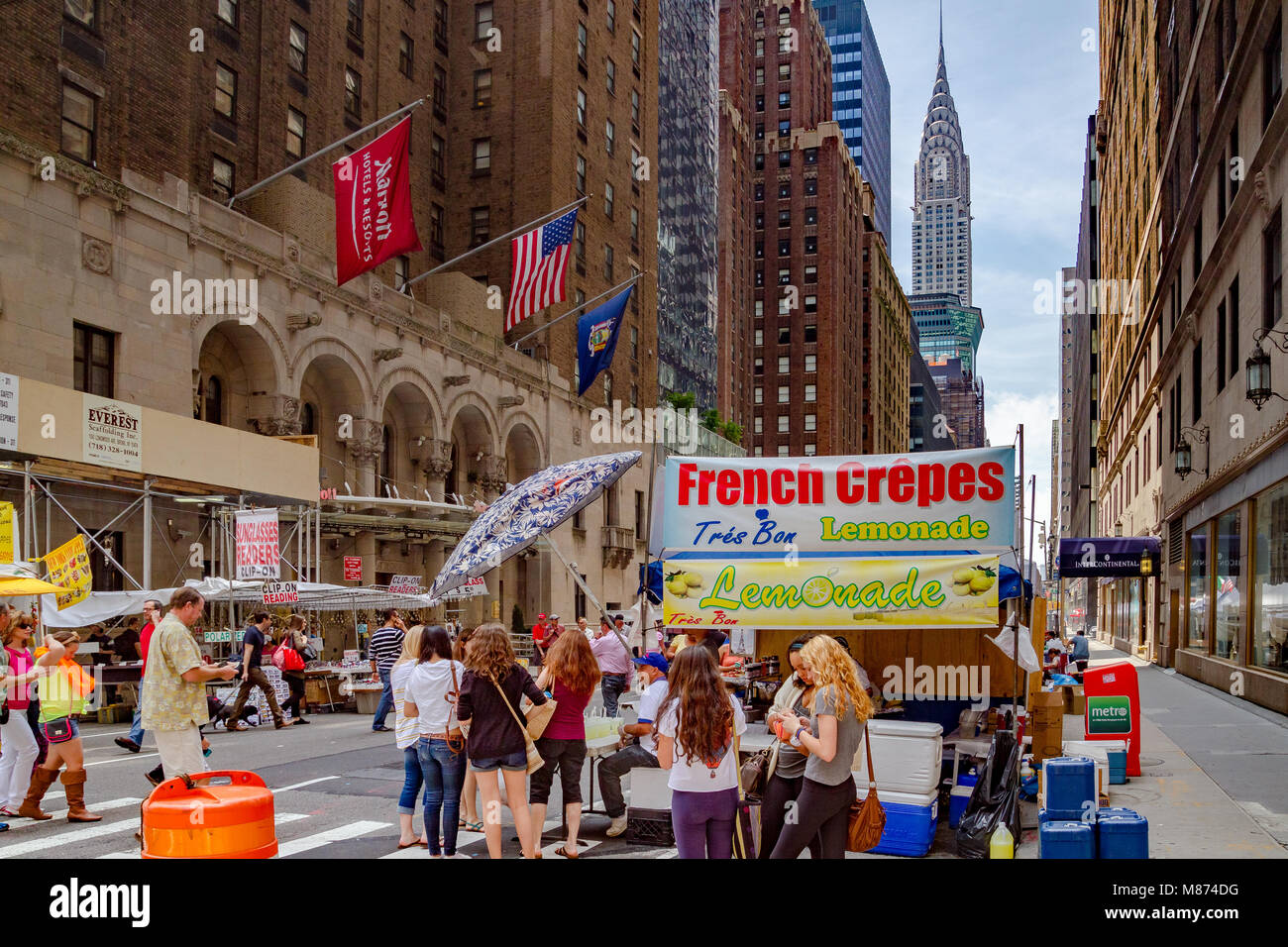 Les gens qui achètent des crêpes français à un marché le dimanche sur Lexington Avenue avec le Chrysler Building au loin, Manhattan, New York City Banque D'Images