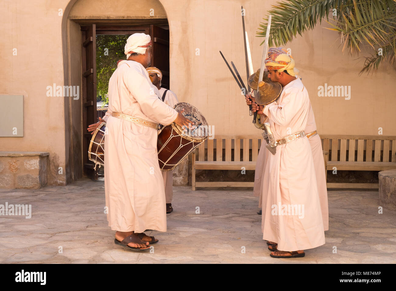 Nizwa, Oman - Omani men danse une danse de l'épée traditionnelle à Nizwa Fort Banque D'Images