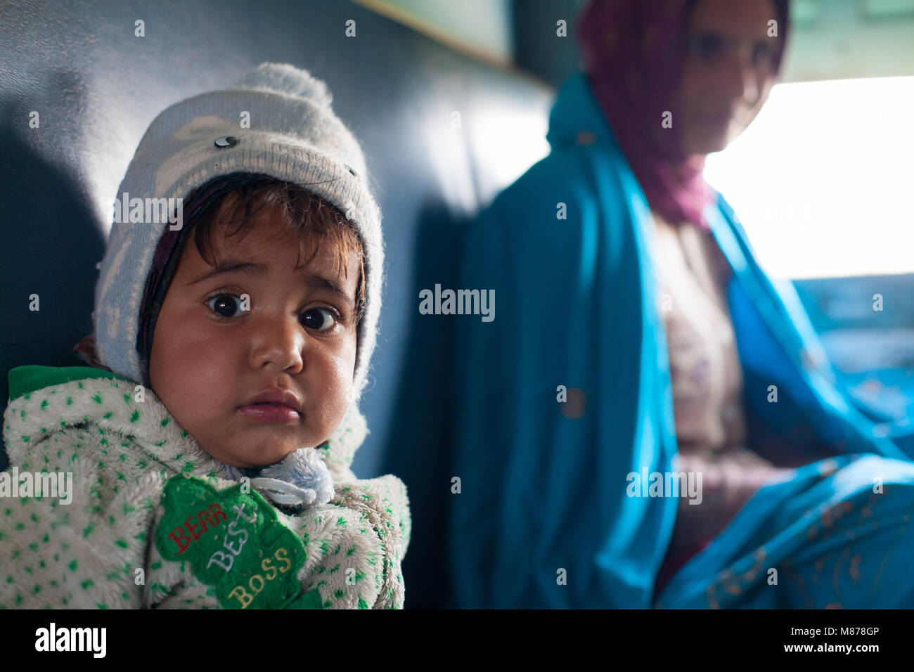 Un portrait d'une petite fille indienne avec mère assis à côté de la fenêtre. Femme est souriante, portant une écharpe châle bleu et violet. Le bébé est nous Banque D'Images
