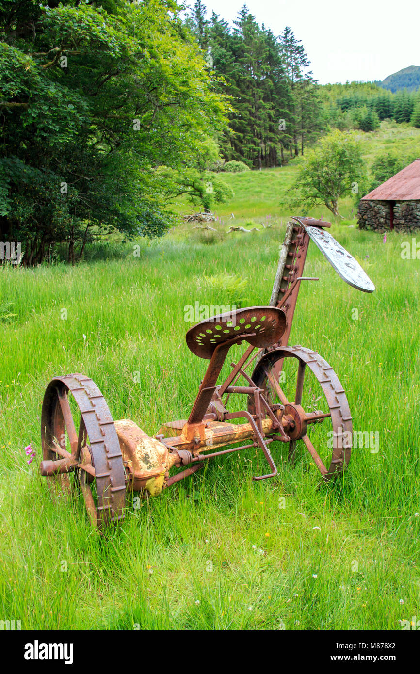 Le fauchage de l'herbe agricole Vintage garée dans l'herbe haute de la machine Banque D'Images