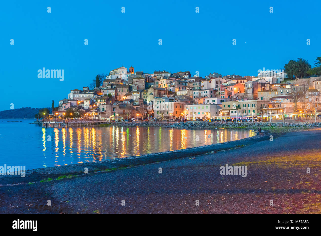 Carpi, Italie - Le lac de Bracciano, au coucher du soleil de la vieille ville de pierre sur le bord de l'eau. Province de Rome, Italie centrale Banque D'Images