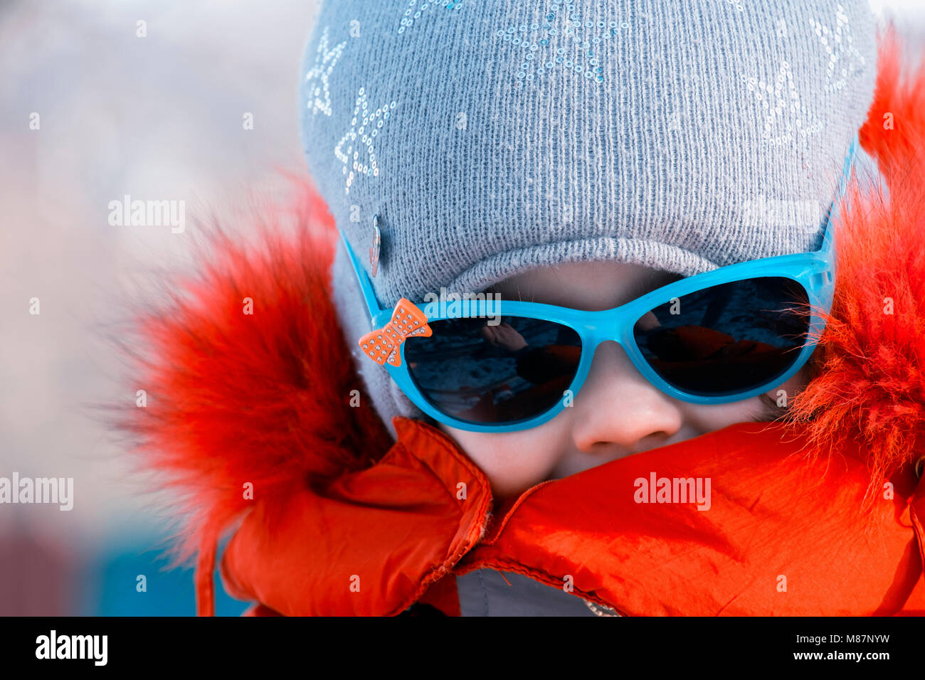 Portrait d'une petite fille à lunettes de soleil en hiver Banque D'Images