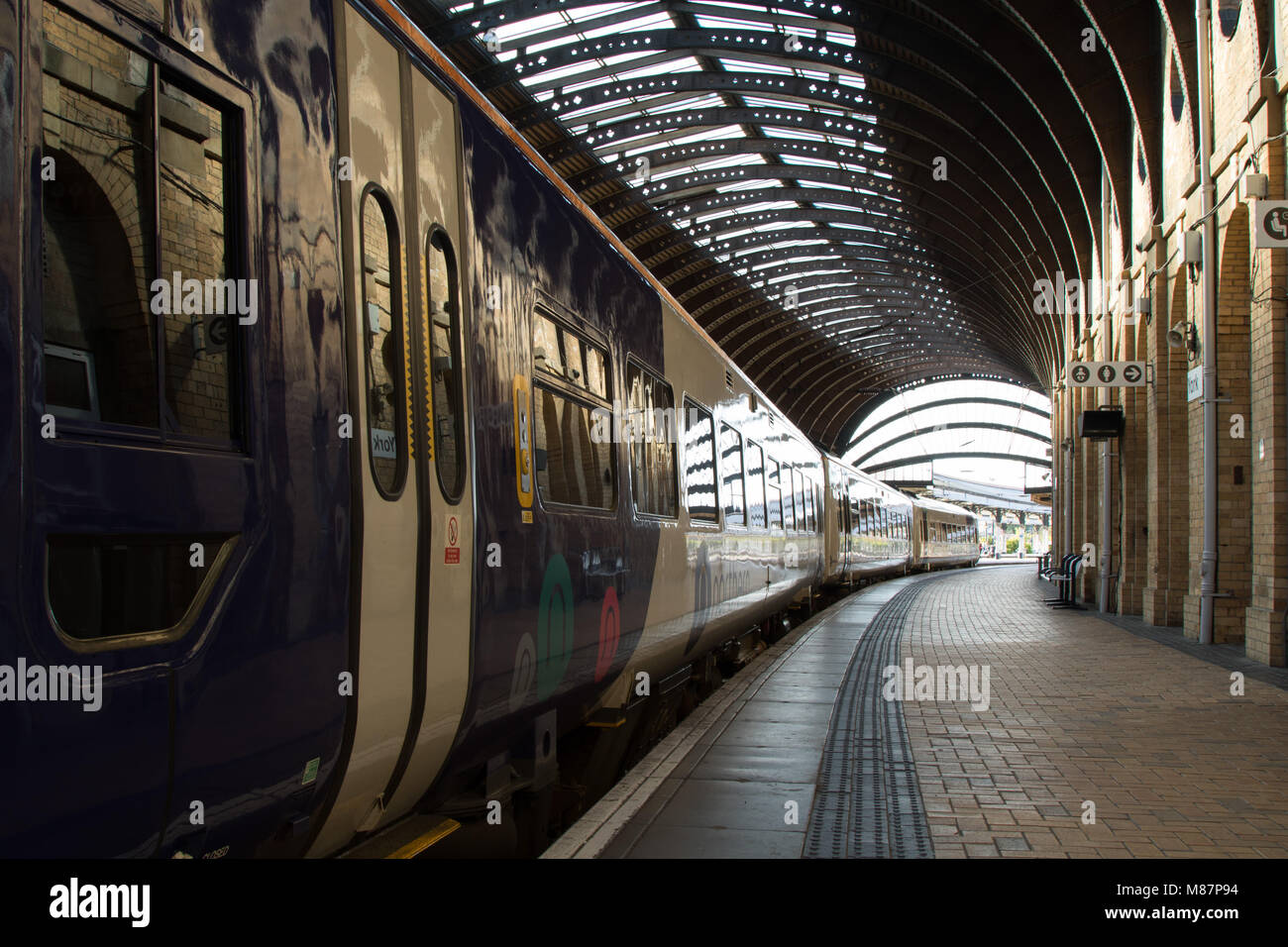 Train par la plate-forme à la gare de York, North Yorkshire, Angleterre, Royaume-Uni. Banque D'Images