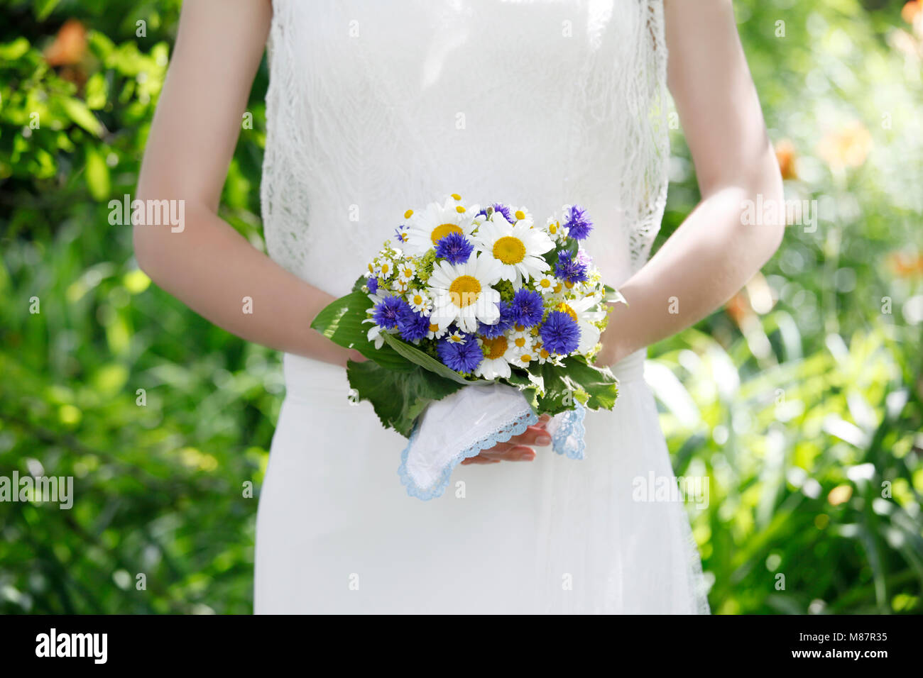 Une mariée en robe blanche tenant un bouquet de mariage, pas de visage Banque D'Images