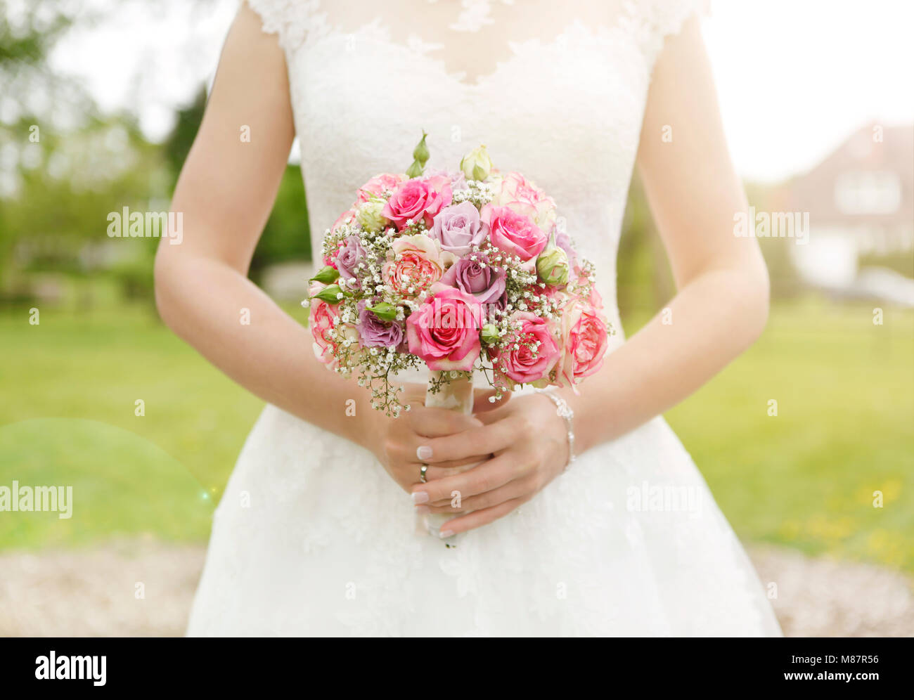 Une mariée en robe blanche tenant un bouquet de mariage, pas de visage Banque D'Images