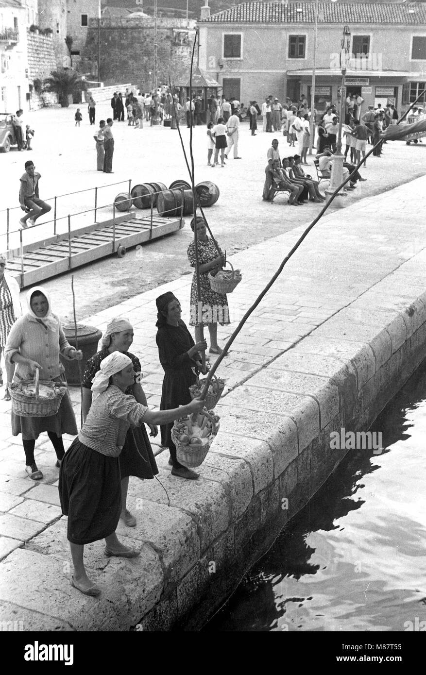 Dubrovnik 1939 Harbour Scene - les femmes semblent pêcher, côte dalmate, mais ils utilisent des tiges pour passer des produits aux passagers de navires de croisière. Banque D'Images